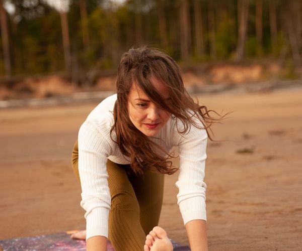 Person stretching outdoors, feeling the flow of energy and nature.